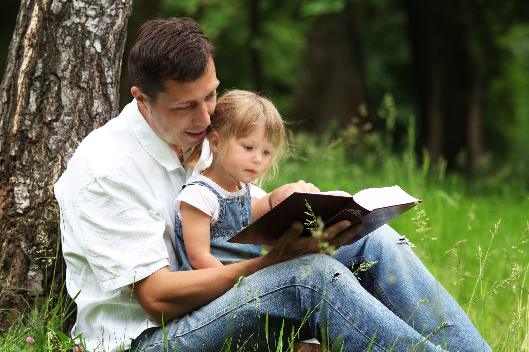 child and father reading the bible